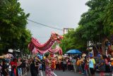 Sejumlah pemain liang liong beraksi di depan penonton saat kirab barongsai dan liang liong di Kota Madiun, Jawa Timur, Senin (27/1/2025). Kegiatan tersebut merupakan rangkaian kegiatan Festival Kampung Pecinan untuk menyambut Tahun Baru Imlek 2576/2025. Antara Jatim/Siswowidodo/um 