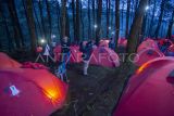 Pengunjung berswafoto di antara tenda di camping ground wisata Tenjo laut, Cigugur, Kuningan, Jawa Barat, Minggu (26/1/2025). Destinasi wisata camping ground yang berada di kawasan konservasi Taman Nasional Gunung Ciremai (TNGC) itu menyewakan tenda dengan pemandangan Gunung Ciremai dan Waduk Darma dengan sewa per malam Rp250 ribu hingga Rp1,5 juta. ANTARA FOTO/Dedhez Anggara/foc.