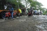 Sejumlah kendaraan menerobos banjir di jalan raya pantura (Pantura) Desa Pasir Putih, Bungatan, Situbondo, Jawa Timur, Rabu (5/2/2025). Banjir luapan air sungai tersebut membawa material batu, pasir yang menutup akses jalan raya Pantura Situbondo mengakibatkan kemacetan sekitar delapan kilometer dari arah Surabaya ke Banyuwangi dan sebaliknya. Antara Jatim/Seno/um