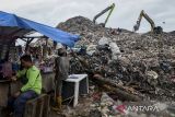 Pemulung istirahat di dekat alat berat yang mengeruk sampah di Tempat Pembuangan Akhir (TPA) Jatiwaringin, Kabupaten Tangerang, Banten, Kamis (6/2/2025). Kementerian Lingkungan Hidup berencana menutup tiga TPA di wilayah Tangerang yang masih mengelola sampah dengan metode lahan terbuka atau open dumping yaitu TPA Jatiwaringin, TPA Rawa Kucing dan TPA Cipeucang. ANTARA FOTO/Putra M. Akbar/gp