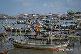 Seorang anak berjalan di dekat perahu yang bersandar di kawasan pesisir Desa Tanjung Anom, Kabupaten Tangerang, Banten, Kamis (6/2/2025). Ombudsman RI Provinsi Banten mengatakan keberadaan pagar laut di pesisir Kabupaten Tangerang berdampak terhadap 3.888 nelayan dengan total jumlah kerugian mencapai Rp 24 mililar terhitung sejak Agustus 2024 hingga Januari 2025. ANTARA FOTO/Putra M. Akbar/gp