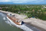Foto udara eks KRI Teluk Bone 511 yang terdampar dalam kondisi berkarat di Pantai Pariaman, Sumatera Barat, Rabu (5/2/2025). Pemkot Pariaman menegaskan larangan bagi wisatawan dan warga untuk menaiki kapal perang yang masih ditunda untuk dijadikan museum itu karena kondisinya yang belum stabil dan aman sehingga dikhawatirkan dapat membahayakan keselamatan pengunjung. ANTARA FOTO/Iggoy el Fitra/rwa.