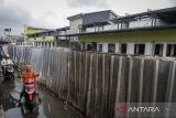 Pengendara motor melintas di dekat proyek revitalisasi Pasar Anyar, Kota Tangerang, Banten, Jumat (7/2/2025). Pemerintah Kota Tangerang menargetkan revitalisasi pasar yang merupakan Proyek Strategis Nasional (PSN) tersebut selesai pada Februari 2025 dan saat ini telah mencapai 97,5 persen. ANTARA FOTO/Putra M. Akbar/gp