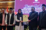 Ketua KPU Banyuwangi Dian Purnawan (kedua kanan) menyerahkan Surat Keputusan kepada Bupati dan Wakil Bupati Banyuwangi terpilih Ipuk Fiestiandani (tengah) dan Mujiono (kedua kiri) pada Rapat Pleno Terbuka Penetapan Bupati dan Wakil Bupati di Banyuwangi, Jawa Timur, Jumat (7/2/2025). KPU Banyuwangi menetapkan pasangan Ipuk Fiestiandani-Mujiono sebagai Bupati dan Wakil Bupati Banyuwangi terpilih dengan perolehan suara 404.366 suara atau 52,11 persen dari total suara sah. ANTARA Jatim/Budi Candra Setya/mas.