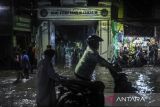 Pengendara roda dua mendorong motornya yang mogok akibat menerjang banjir di Cimanggung, Kota Serang, Banten, Jumat (7/2/2025). Banjir yang merendam jalan raya hingga kawasan pemukiman dengan ketinggian air mencapai 40 sentimeter hingga 120 sentimeter tersebut terjadi akibat tingginya intensitas curah hujan disertai buruknya saluran drainase. ANTARA FOTO/Muhammad Bagus Khoirunas/gp