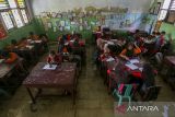  Sejumlah siswa mengikuti kegiatan belajar mengajar di salah satu ruang kelas yang terendam banjir di SD Negeri Eretan, Tirtayasa, Kabupaten Serang, Banten, Sabtu (8/2/2025). Pihak sekolah menyebutkan sejak enam tahun terakhir sekolah tersebut menjadi langganan banjir akibat luapan saluran irigasi yang ada di sekitar area sekolah dengan ketinggian air sekitar 25-30 centimeter dan merendam sebanyak enam ruang kelas, satu ruang guru, dan dua gudang sekolah. ANTARA FOTO/Angga Budhiyanto/gp