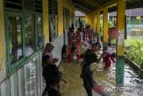Sejumlah siswa bermain air di depan ruang kelas yang terendam banjir di SD Negeri Eretan, Tirtayasa, Kabupaten Serang, Banten, Sabtu (8/2/2025). Pihak sekolah menyebutkan sejak enam tahun terakhir sekolah tersebut menjadi langganan banjir akibat luapan saluran irigasi yang ada di sekitar area sekolah dengan ketinggian air sekitar 25-30 centimeter dan merendam sebanyak enam ruang kelas, satu ruang guru, dan dua gudang sekolah. ANTARA FOTO/Angga Budhiyanto/gp