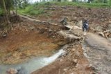 Warga melintasi jembatan darurat yang baru dibuat di Desa Rajekwesi, Kendit, Situbondo, Jawa Timur,  Jumat (7/2/2025). Sebanyak 92 kepala keluarga atau 217 jiwa warga Dusun Krajan Barat dan Krajan Timur, Desa Rajekwesi kembali beraktivitas setelah terisolir akibat jembatan satu-satunya yang menjadi akses warga setempat putus diterjang banjir pada Senin (3/2). Antara Jatim/Seno/mas.
