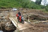 Warga melintasi jembatan darurat yang baru dibuat di Desa Rajekwesi, Kendit, Situbondo, Jawa Timur,  Jumat (7/2/2025). Sebanyak 92 kepala keluarga atau 217 jiwa warga Dusun Krajan Barat dan Krajan Timur, Desa Rajekwesi kembali beraktivitas setelah terisolir akibat jembatan satu-satunya yang menjadi akses warga setempat putus diterjang banjir pada Senin (3/2). Antara Jatim/Seno/mas.