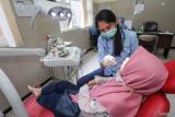 Petugas medis memeriksa gigi pasien saat pelaksanaan program Pemeriksaan Kesehatan Gratis (PKG) di Puskesmas Menganti, Gresik, Jawa Timur, Senin (10/2/2025). Program PKG yang dimulai serentak pada 10 Februari 2025 di 10.200 Puskesmas di seluruh Indonesia tersebut bertujuan untuk meningkatkan kualitas kesehatan masyarakat Indonesia dan mengurangi beban penyakit yang bisa dicegah. Antara Jatim/Rizal Hanafi/um