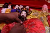 Dalang Sutarto merapikan jenggot salah satu karakter wayang potehi sebelum dimainkan di Kelenteng Eng An Kiong, Malang, Jawa Timur, Senin (10/2/2025). Pementasan wayang potehi untuk menyambut perayaan Cap Go Meh tersebut mengangkat kisah kecerdikan Jenderal Yo Bun Kong dari kerajaan Song Kio saat memimpin serangan untuk menaklukkan kerajaan La Ban Ko. ANTARA Jatim/Ari Bowo Sucipto/mas.