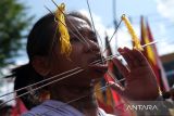 Seorang tatung (dukun Tionghoa yang kerasukan arwah leluhur) beratraksi di atas tandu saat mengikuti pawai Perayaan Cap Go Meh 2025 di Kota Singkawang, Kalimantan Barat, Rabu (12/2/2025). Sebanyak 736 Tatung, kelompok altar dan jelangkung asal Singkawang mengikuti pawai perayaan Cap Go Meh yang digelar Pemerintah Kota Singkawang setelah hari ke-15 Tahun Baru Imlek. ANTARA FOTO/Jessica Wuysang