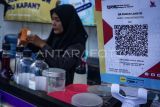 Pedagang menyiapkan pesanan pembeli di gerobaknya dengan menyediakan pembayaran digital QRIS di Balikpapan, Kalimantan Timur, Selasa (11/2/2025). Kantor Perwakilan Bank Indonesia (KPwBI) Balikpapan mencatat sepanjang tahun 2024 transaksi non-tunai melalui QRIS mencapai Rp4,13 triliun dengan total volume transaksi sebanyak 27.694.128. Antara Kaltim/Aditya Nugroho/mrh