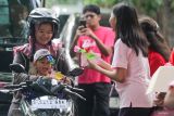 Siswa SMAS Katolik Untung Suropati memberikan nasi bungkus kepada pengendara di Jalan Untung Surapati, Sidoarjo, Jawa Timur, Jumat (14/2/2025). Sekitar 300 paket nasi bungkus dibagikan kepada pengendara yang melintas untuk merayakan hari Valentine sebagai bentuk kasih sayang kepada sesama. Antara Jatim/Umarul Faruq