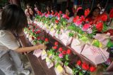 Siswa SMAS Katolik Untung Suropati menata nasi bungkus untuk dibagikan kepada pengendara di Jalan Untung Surapati, Sidoarjo, Jawa Timur, Jumat (14/2/2025). Sekitar 300 paket nasi bungkus dibagikan kepada pengendara yang melintas untuk merayakan hari Valentine sebagai bentuk kasih sayang kepada sesama. Antara Jatim/Umarul Faruq