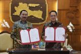 Pj Gubernur Jawa Timur Adhy Karyono (kanan) bersama Rektor Institut Pemerintahan Dalam Negeri (IPDN) Hadi Prabowo (kiri) memperlihatkan nota keseoakatan bersama usai ditandatangani di Gedung Negara Grahadi  Surabaya, Jawa Timur, Jumat (14/2/2025). Pemerintah Provinsi Jawa Timur bekerja sama dengan IPDN untuk pembentukan SMA Negeri 2 Taruna Pamong Praja Bojonegoro sebagai uapaya meningkatkan kualitas pendidikan, pembentukan karakter, pembekalan di bidang ilmu kepemerintahan serta kesamaptaan sekaligus mempersiapkan taruna/taruni agar mampu bersaing di Perguruan Tinggi Negeri (PTN), sekolah kedinasan dan menjadi calon pemimpin baru bangsa. ANTARA Jatim/Moch Asim.