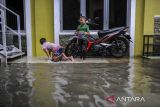 Dua anak bermain air saat banjir menggenangi pemukimannya di Rangkasbitung, Lebak, Banten, Sabtu (15/2/2025). Banjir yang terjadi akibat curah hujan tinggi tersebut menyebabkan sejumlah akses jalan raya serta empat titik kawasan pemukiman di Rangkasbitung terendam banjir setinggi sekitar 30 hingga 60 sentimeter. ANTARA FOTO/Muhammad Bagus Khoirunas/gp