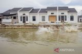 Anak-anak bermain di kolam pengendali banjir di perumahan subsidi di Indramayu, Jawa Barat, Sabtu (15/2/2025). PT Bank Tabungan Negara Tbk telah menyalurkan KPR untuk masyarakat berpendapatan rendah (MBR) dengan skema fasilitas likuiditas pembiayaan perumahan (FLPP) atau KPR subsidi kepada pekerja sektor informal sebesar 10 persen dari total penyaluran KPR FLPP emiten berkode BBTN. ANTARA FOTO/Dedhez Anggara/agr
