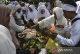 Warga menyantap nasi tumpeng saat tradisi adat Nyepuh di Desa Ciomas, Kecamatan Panjalu, Kabupaten Ciamis, Jawa Barat, Minggu (16/2/2025). Tradisi budaya Nyepuh yang merupakan upacara adat warga Desa Ciomas secara turun temurun tersebut untuk mensucikan diri lahir dan batin sebelum melaksanakan ibadah puasa di bulan suci Ramadan, diantaranya bersih-bersih makam, ziarah kubur, tawasul, menanam pohon dan makan nasi tumpeng bersama. ANTARA FOTO/Adeng Bustomi/agr