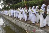 Tokoh adat dan masyarakat membawa kembang menuju makam KH Eyang Penghulu Gusti saat tradisi adat Nyepuh di Desa Ciomas, Kecamatan Panjalu, Kabupaten Ciamis, Jawa Barat, Minggu (16/2/2025). Tradisi budaya Nyepuh yang merupakan upacara adat warga Desa Ciomas secara turun temurun tersebut untuk mensucikan diri lahir dan batin sebelum melaksanakan ibadah puasa di bulan suci Ramadan, diantaranya bersih-bersih makam, ziarah kubur, tawasul, menanam pohon dan makan nasi tumpeng bersama. ANTARA FOTO/Adeng Bustomi/agr