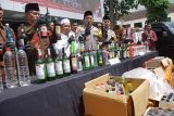Kapolres Jombang, AKBP Ardi Kurniawan (tengah) menunjukkan miras didampingi tokoh agama saat rilis di Mapolres Kabupaten Jombang, Jawa Timur, Selasa (18/2/2025). Polres Jombang berhasil mengamankan 2,6 ribu botol minuman keras (miras) berbagai merk hasil razia selama lima hari untuk menjaga keamanan dan ketertiban masyarakat (kamtibmas). ANTARA Jatim/Syaiful Arif/mas.