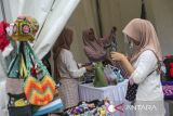 Pengunjung memilih produk kerajinan yang dijajakan pada gelaran gebyar pasar rakyat dan UMKM di Alun-alun Barat Kota Serang, Banten, Rabu (19/2/2025). Acara yang diisi dengan beragam kegiatan seperti bazar UMKM, gebyar pasar rakyat, lomba marawis, kreasi baris berbaris, dan pemeriksaan kesehatan gratis tersebut digelar dalam rangka memeriahkan HUT Ke-17 Partai Gerindra. ANTARA FOTO/Angga Budhiyanto/gp