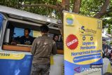 Petugas Dinas Penanaman Modal dan Pelayanan Terpadu Satu Pintu melayani warga yang akan membuat Nomor Induk Berusaha (NIB) saat pelayanan jemput bola di Jalan Nilem, Bandung, Jawa Barat, Rabu (19/2/2025). Pemerintah Kota Bandung melakukan pelayanan jemput bola bagi masyarakat yang akan membuat NIB dalam upaya meningkatkan akses dan kenyamanan bagi pelaku usaha mikro melalui program Sakedap (Sarana Anjungan Kemudahan Perizinan). ANTARA FOTO/Raisan Al Farisi/agr