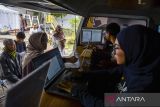 Petugas Dinas Penanaman Modal dan Pelayanan Terpadu Satu Pintu melayani warga yang akan membuat Nomor Induk Berusaha (NIB) saat pelayanan jemput bola di Jalan Nilem, Bandung, Jawa Barat, Rabu (19/2/2025). Pemerintah Kota Bandung melakukan pelayanan jemput bola bagi masyarakat yang akan membuat NIB dalam upaya meningkatkan akses dan kenyamanan bagi pelaku usaha mikro melalui program Sakedap (Sarana Anjungan Kemudahan Perizinan). ANTARA FOTO/Raisan Al Farisi/agr