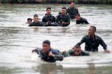 Prajurit Korps Marinir TNI AL berenang sambil mengamankan perlengkapan organik dalam lomba pentathlon di Kesatrian Marinir R. Suhadi Gedangan, Sidoarjo, Jawa Timur, Kamis (20/2/2025). Lomba tersebut bertujuan untuk meningkatkan kemampuan fisik prajurit Korps Marinir yang profesional sebagai pasukan pendarat yang siap menghadapi tantangan. Antara Jatim/Umarul Faruq