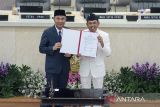 Gubernur Jawa Barat Dedi Mulyadi (kanan) bersama Pj Gubernur Jawa Barat Bey Machmudin menunjukkan dokumen saat serah terima jabatan Gubernur Jawa Barat di Gedung DPRD Jawa Barat, Bandung, Jawa Barat, Jumat (21/2/2025). Dedi Mulyadi dan Erwan Setiawan resmi mengemban tugas sebagai Gubernur dan Wakil Gubernur Provinsi Jawa Barat periode 2025-2030 dengan mengedepankan visi Jabar Istimewa, Kampung Diurus Kota Ditata. ANTARA FOTO/Novrian Arbi/agr
