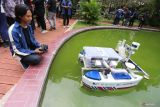 Tim Barunastra Institut Teknologi Sepuluh Nopember (ITS) Andi Abdillah (kiri) menguji coba purwarupa kapal robot Nala Ares di kolam depan Rektorat ITS, Surabaya, Jawa Timur, Jumat (21/2/2025). Kapal tak berawak dengan sistem propulsi mutakhir itu mampu bergerak secara presisi, menyemprotkan air, menembakkan bola, melaju hingga kecepatan 5 knot yang dilengkapi sensor LiDAR untuk memetakan arena dan dipersiapkan untuk mengikuti International Roboboat Competition (IRC) 2025 pada 3-9 Maret di Nathan Benderson Park, Florida, Amerika Serikat. ANTARA Jatim/Moch Asim.
