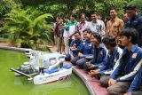 Rektor Institut Teknologi Sepuluh Nopember (ITS) Bambang Pramujati (kedua kanan atas) saat berfoto dengan Tim Barunastra ITS di sela-sela uji coba purwarupa kapal robot Nala Ares di kolam Rektorat ITS di Surabaya, Jawa Timur, Jumat (21/2/2025). Kapal tak berawak dengan sistem propulsi mutakhir itu mampu bergerak secara presisi, menyemprotkan air, menembakkan bola, melaju hingga kecepatan 5 knot yang dilengkapi sensor LiDAR untuk memetakan arena dan dipersiapkan untuk mengikuti International Roboboat Competition (IRC) 2025 pada 3-9 Maret di Nathan Benderson Park, Florida, Amerika Serikat. ANTARA Jatim/Moch Asim.