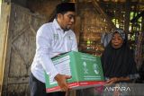 Petugas Baznas menyerahkan bantuan paket sembako kepada penerima manfaat di Mandalawangi, Pandeglang, Banten, Sabtu (22/2/2025). Badan Amil Zakat Nasional (Baznas) bekerja sama dengan Kerajaan Arab Saudi melalui King Salman Humanitarian Aid & Centre (KSrelief) menyalurkan bantuan pangan sebanyak 7.911 paket di empat provinsi di Indonesia sebagai upaya membantu memenuhi kebutuhan pokok bagi keluarga prasejahtera selama bulan Ramadhan. ANTARA FOTO/Muhammad Bagus Khoirunas/gp