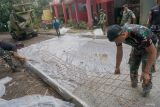 Prajurit TNI memasang rangka besi untuk pengecoran jalan (rabat) di sekitar pemukiman lereng Gunung WIlis Desa Nglurup, Kecamatan Sendang, Tulungagung, Jawa Timur, Sabtu (22/2/2025). Dalam kegiatan TMMD ke-123 itu, TNI membantu proses rabat jalan beton sdepanjang 1.005 meter, renovasi masjid, pembangunan lima unit jamban keluarga dan empat MCK umum, penyediaan tiga titik sumur bor, penghijuan, serta bedah rumah tidak layak huni di delapan sasaran keluarga prasejahtera. .ANTARA Jatim/Destyan Sujarwoko/mas.
