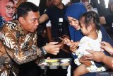 Menteri Kependudukan dan Pembangunan Keluarga (Mendukbangga)/Kepala BKKBN Wihaji (kiri) memberikan paket Makanan Bergizi Gratis kepada anak balita saat melakukan kunjungan kerja di Kota Madiun, Jawa Timur, Rabu (26/2/2025). Dalam kunjungan kerjanya Menteri Wihaji antara lain meninjau pelaksanaan simulasi distribusi paket Makanan Bergizi Gratis (MBG) untuk ibu hamil dan menyusui serta anak balita nonPendidikan Anak Usia Dini (PAUD). Antara Jatim/Siswowidodo/um 