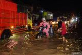Sejumlah kendaraan melintas di jalan yang terendam banjir di simpang empat Cuwiri, Tulungagung, Jawa Timur, Rabu (26/2/2025).. Banjir dpicu hujan tanggul jebol pascaturun hujan deras itu merendam ratusan rumah warga, area persawahan hingga akses jalan raya terendam air hingga lutut orang dewasa. ANTARA Jatim/Destyan Sujarwoko/mas.
