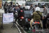 Polisi mengarahkan pengendara sepeda motor ke tempat pemeriksaan surat kendaraan saat operasi pajak kendaraan di Kota Tangerang, Banten, Kamis (27/2/2025). Operasi gabungan yang melibatkan Badan Pendapatan Daerah Kota Tangerang, Jasa Raharja dan Polres Metro Tangerang Kota tersebut untuk meningkatkan kepatuhan masyarakat dalam membayar pajak kendaraan bermotor sekaligus  sebagai upaya mendongkrak pendapatan daerah. ANTARA FOTO/Putra M. Akbar/gp