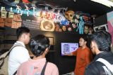 Petugas menjelaskan tradisi kematian kepada pengunjung di Museum Etnografi dan Pusat Kajian Kematian, Universitas Airlangga (Unair), Surabaya, Jawa Timur, Kamis (27/2/2025). Museum bertema kematian yang didirikan Departemen Antropologi Fisip Unair pada September 2005 tersebut bertujuan untuk mengenalkan sejarah yang berhubungan dengan etnografi dan tradisi kematian di Nusantara. ANTARA Jatim/Rizal Hanafi/mas.