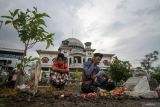 Warga memanjatkan doa untuk keluarga mereka yang telah wafat di makam Kawasan Masjid Baitul Hamdi desa Besuki, Jabon, Sidoarjo, Jawa Timur, Kamis (27/2/2025). Warga menyambut Ramadan dengan melakukan ziarah untuk mendoakan keluarga dan kerabat. Antara Jatim/Umarul Faruq