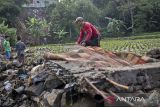 Warga membersihkan puing dinding pembatas yang roboh pascabanjir di Gadobangkong, Ngamprah, Kabupaten Bandung Barat, Jawa Barat, Jumat (28/2/2025). Sebanyak 43 unit rumah terdampak banjir yang terjadi akibat meluapnya air dari aliran irigasi yang tertutup longsoran dinding penahan tanah. ANTARA FOTO/Abdan Syakura/agr
