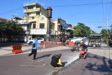 Pekerja melakukan pembenahan jalan di kawasan Titik Nol Kota Madiun, Jawa Timur, Sabtu (1/3/2025). Pembenahan tersebut dilakukan karena di kawasan tersebut sering terjadi kecelakaan akibat sepeda motor tergelincir pada saat hujan. Antara Jatim/Siswowidodo/mas.