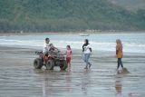 Wisatawan bermain kendaraan ATV (all terrain vehicle) menikmati keindahan suasana sore di pantai Gemah, Tulungagung, Jawa Timur, Minggu (2/3/2025). Sebagian warga yang menjalankan ibadah puasa  memilih untuk meluangkan waktu untuk ngabuburit sambil penyegaran (refresihing) menunggu sore menjelang waktu berbuka puasa. Antara Jatim/Destyan Sujarwoko/um