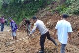 Polisi dan warga bersihkan material longsor tutup jalan di Manggarai Barat