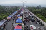 Foto udara warga dan pedagang memadati pasar takjil Ramadhan di Jalan Baru Lingkar Utara, Kota Tasikmalaya, Jawa Barat, Minggu (2/3/2025).  Pedagang takjil Ramadhan menggunakan jalan dan Jembatan Ciloseh untuk berjualan berbagai minuman dan makanan berbuka puasa sehingga mengakibatkan kemacetan parah di sepanjang jalan. ANTARA FOTO/Adeng Bustomi/agr
