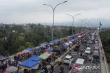 Foto udara warga dan pedagang memadati pasar takjil Ramadhan di Jalan Baru Lingkar Utara, Kota Tasikmalaya, Jawa Barat, Minggu (2/3/2025). Pedagang takjil Ramadhan menggunakan jalan dan Jembatan Ciloseh untuk berjualan berbagai minuman dan makanan berbuka puasa sehingga mengakibatkan kemacetan parah di sepanjang jalan. ANTARA FOTO/Adeng Bustomi/agr