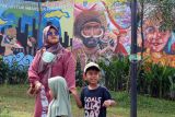 Warga melintas di depan mural bertema keanekaragaman budaya di Depok, Jawa Barat, Kamis (27/2/2025). Mural tersebut sebagai media edukasi kepada masyarakat tentang kekayaan budaya serta mengajarkan nilai toleransi keberagaman Indonesia untuk menjaga persatuan dan kesatuan bangsa. ANTARA FOTO/Yulius Satria Wijaya/foc.