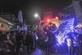 Warga menyaksikan peserta Festival Arakan Sahur melintasi kawasan Tugu Kemerdekaan Kuala Tungkal di Tanjung Jabung Barat, Jambi, Minggu (2/3/2025). Festival yang berawal dari upaya pelestarian tradisi membangunkan sahur tersebut digelar setiap Sabtu malam hingga Minggu dini hari selama Ramadhan dengan diikuti belasan peserta dari perwakilan remaja masjid dan komunitas. ANTARA FOTO/Wahdi Septiawan/foc.

