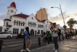 Warga berpose saat mengunjungi kawasan wisata Kota Lama Surabaya, Jawa Timur, Senin (3/3/2025). Kawasan wisata yang terdapat banyak bangunan bersejarah itu menjadi salah satu lokasi bagi masyarakat untuk menunggu waktu berbuka puasa. ANTARA Jatim/Didik Suhartono/mas.