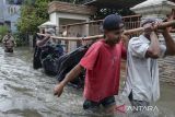 Sejumlah warga memanggul sepeda motor saat banjir di Petir, Kota Tangerang, Banten, Selasa (4/3/2025). Badan Penanggulangan Bencana Daerah (BPBD) Kota Tangerang mencatat terdapat 13 titik genangan air dan banjir di wilayah Kota Tangerang akibat luapan Kali Angke yang dipicu tingginya intensitas hujan sejak Senin (3/3) malam. ANTARA FOTO/Putra M. Akbar/gp