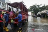 Petugas membantu warga turun dari truk evakuasi saat terjadi banjir di Ciledug, Kota Tangerang, Banten, Selasa (4/3/2025). Badan Penanggulangan Bencana Daerah (BPBD) Kota Tangerang mencatat terdapat 13 titik genangan air dan banjir di wilayah Kota Tangerang akibat luapan Kali Angke yang dipicu tingginya intensitas hujan sejak Senin (3/3) malam. ANTARA FOTO/Putra M. Akbar/gp
